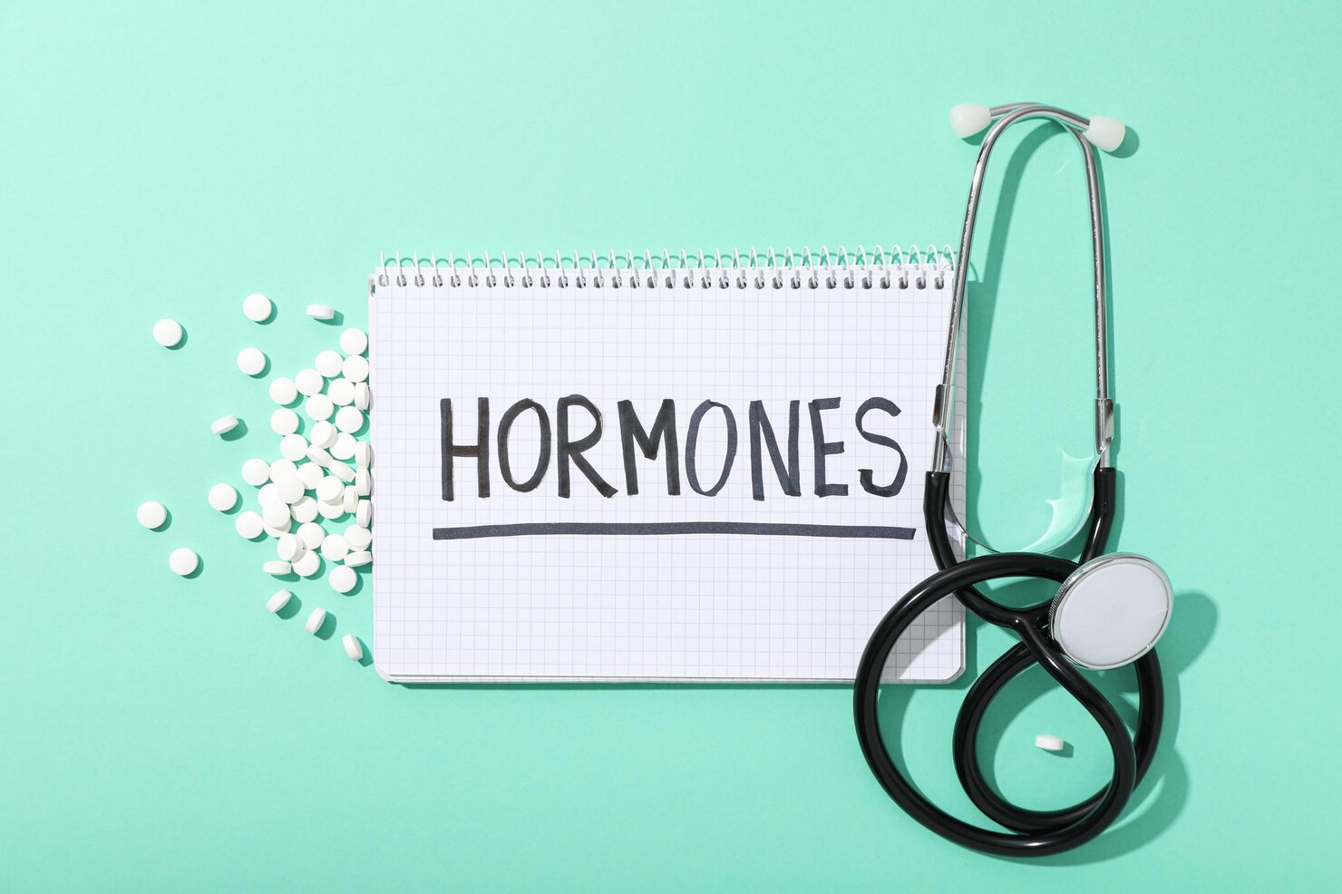 notepad reading hormones next to a stethoscope